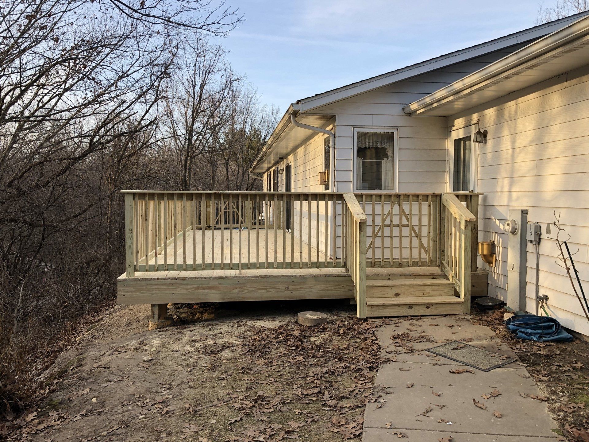 A white house with a wooden deck and stairs