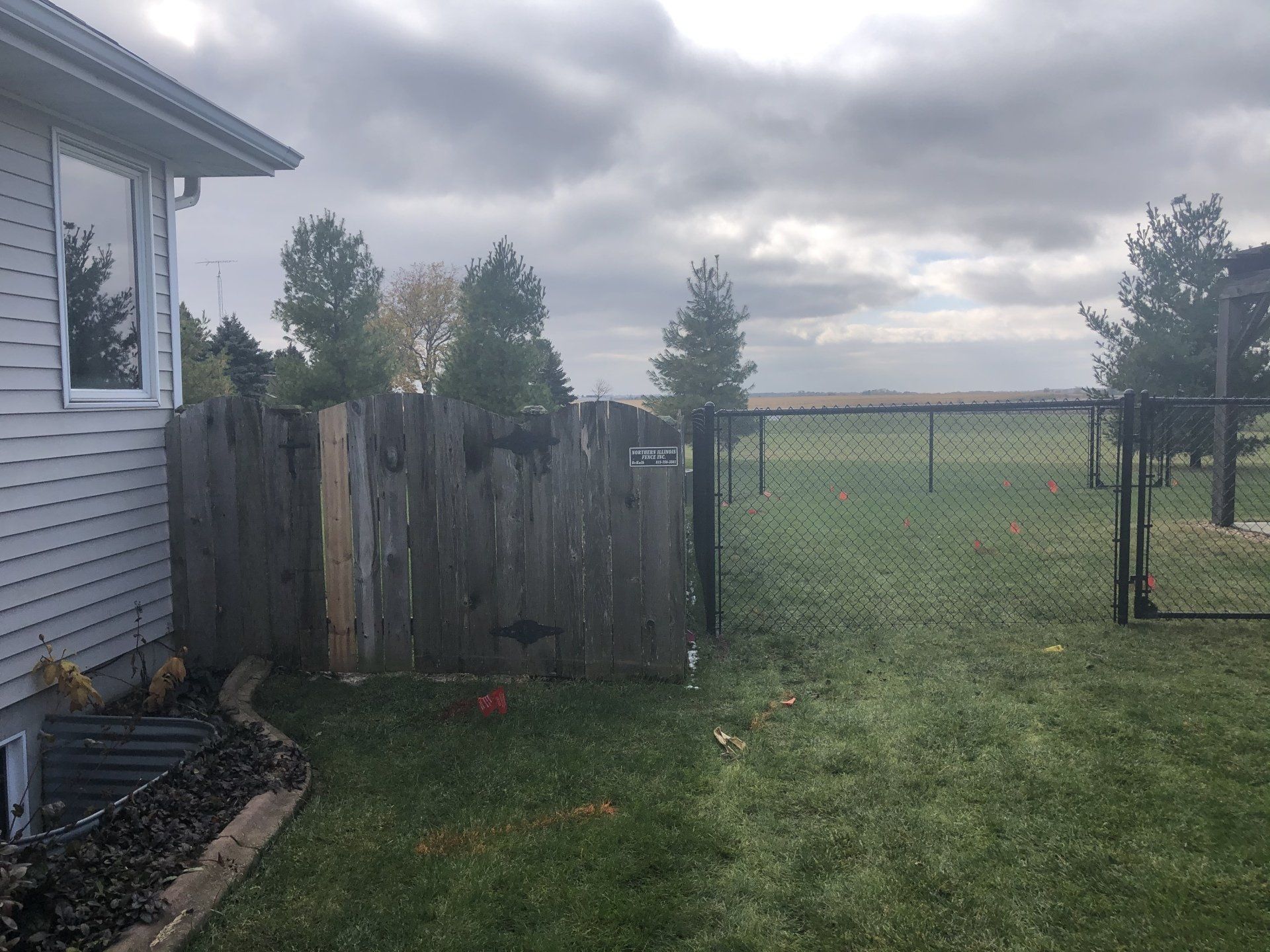 A backyard with a wooden fence and a chain link fence.