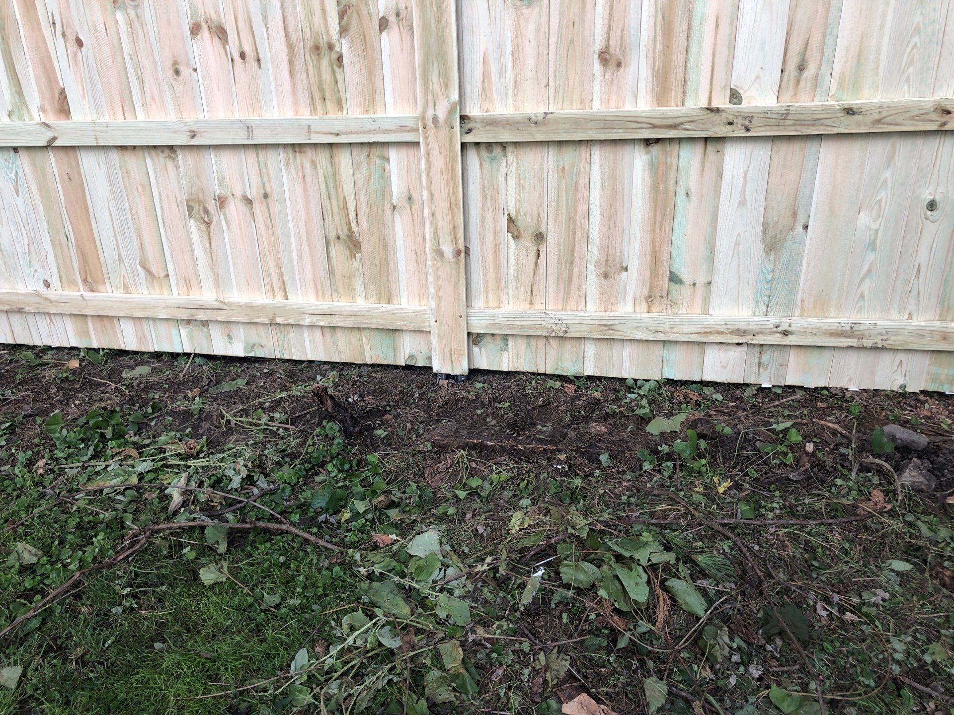A wooden fence is sitting on top of a lush green field.