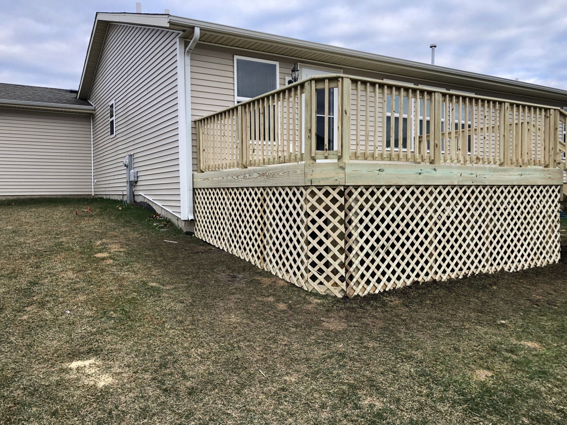 A house with a wooden deck in front of it.