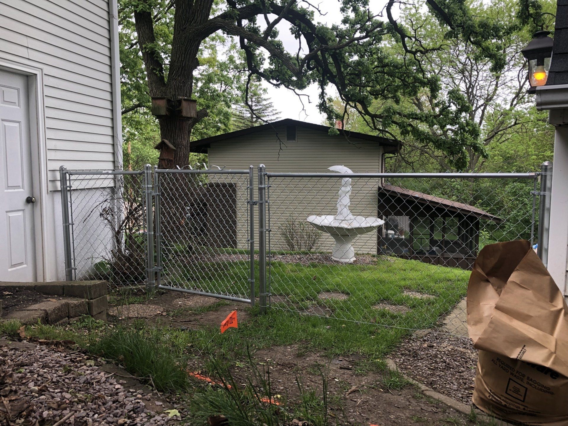 There is a chain link fence in the backyard of a house.