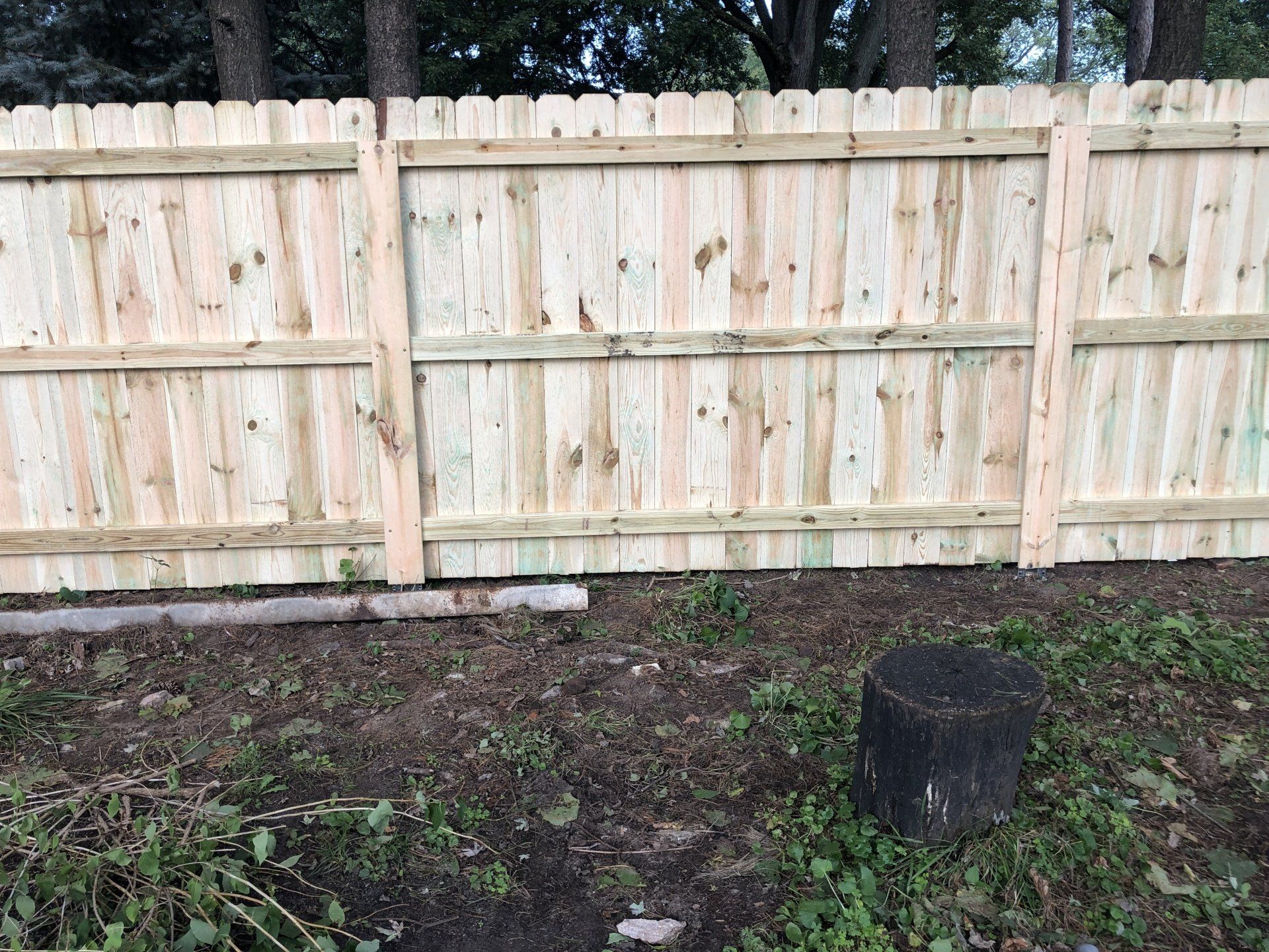 A wooden fence is sitting in the middle of a grassy field.
