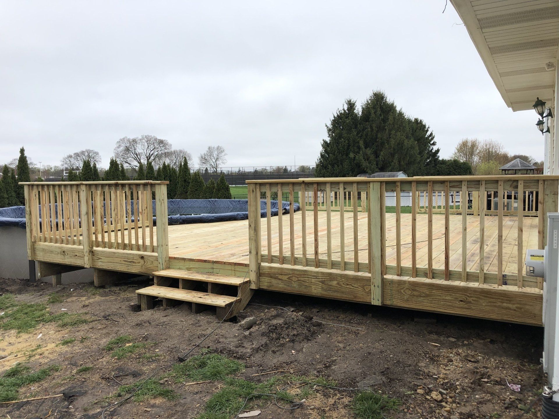 A wooden deck is being built next to a pool.