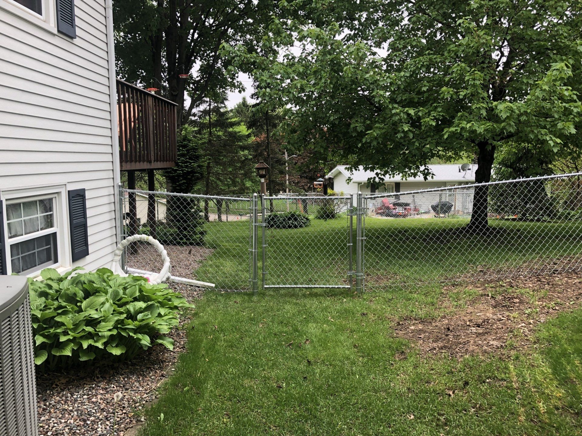 There is a chain link fence in the backyard of a house.