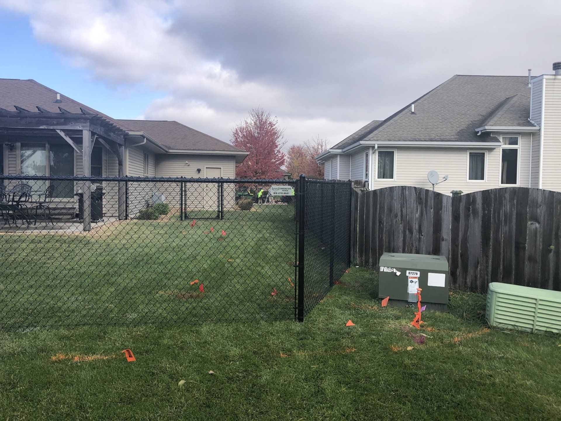 There is a chain link fence in the backyard of a house.