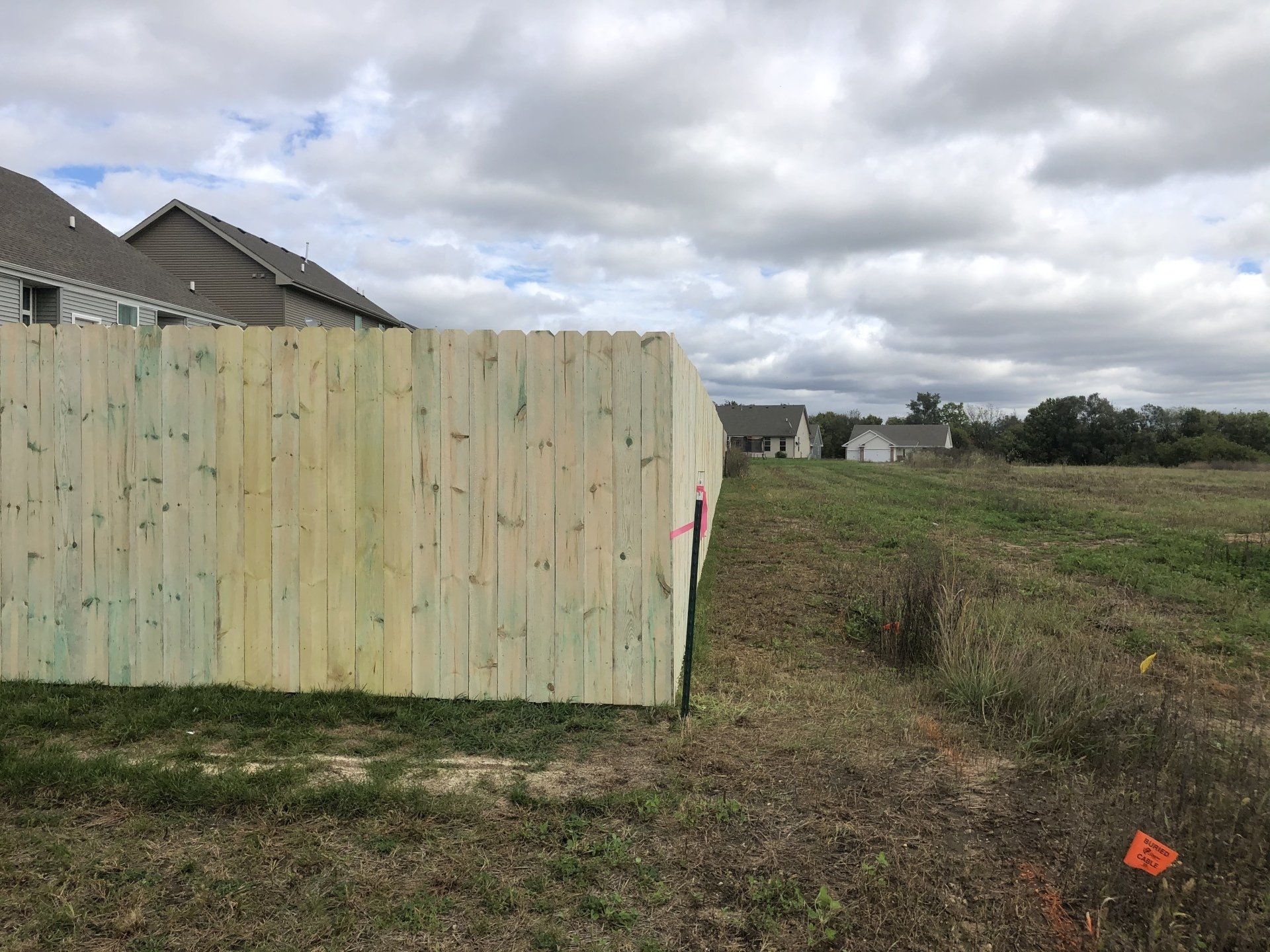 A wooden fence is sitting in the middle of a grassy field.
