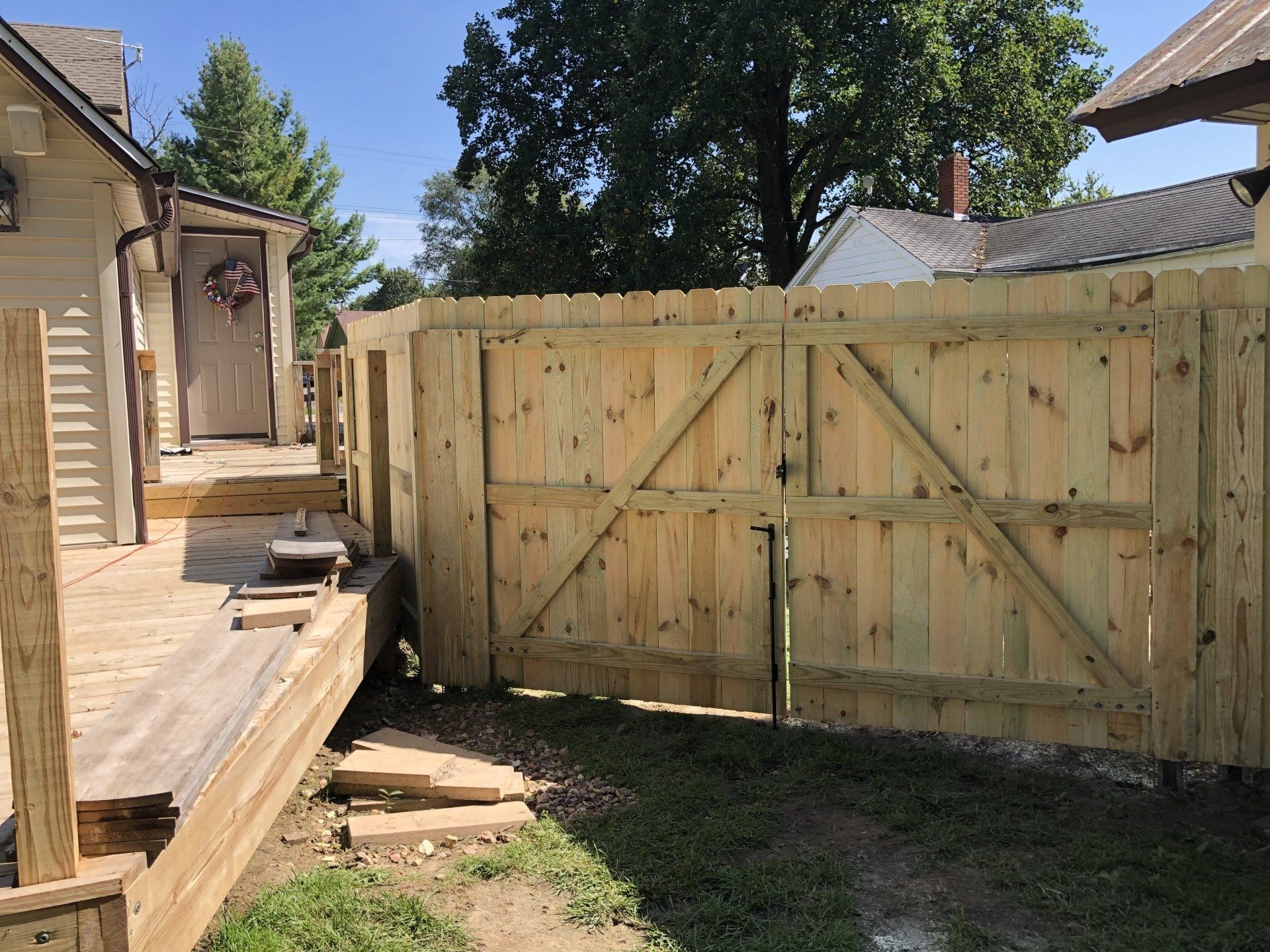 A wooden fence with a gate in front of a house.
