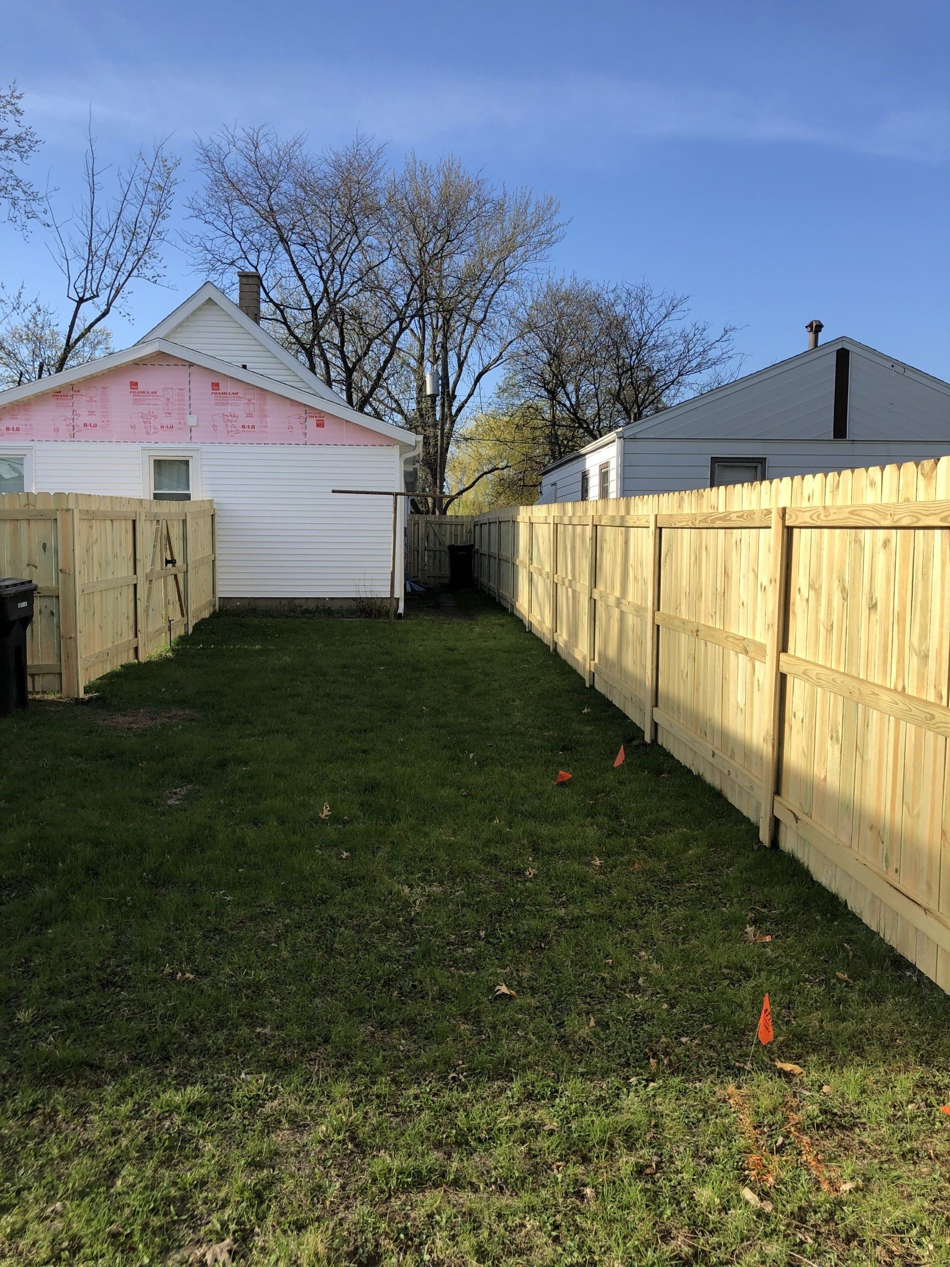 There is a wooden fence in the backyard of a house.