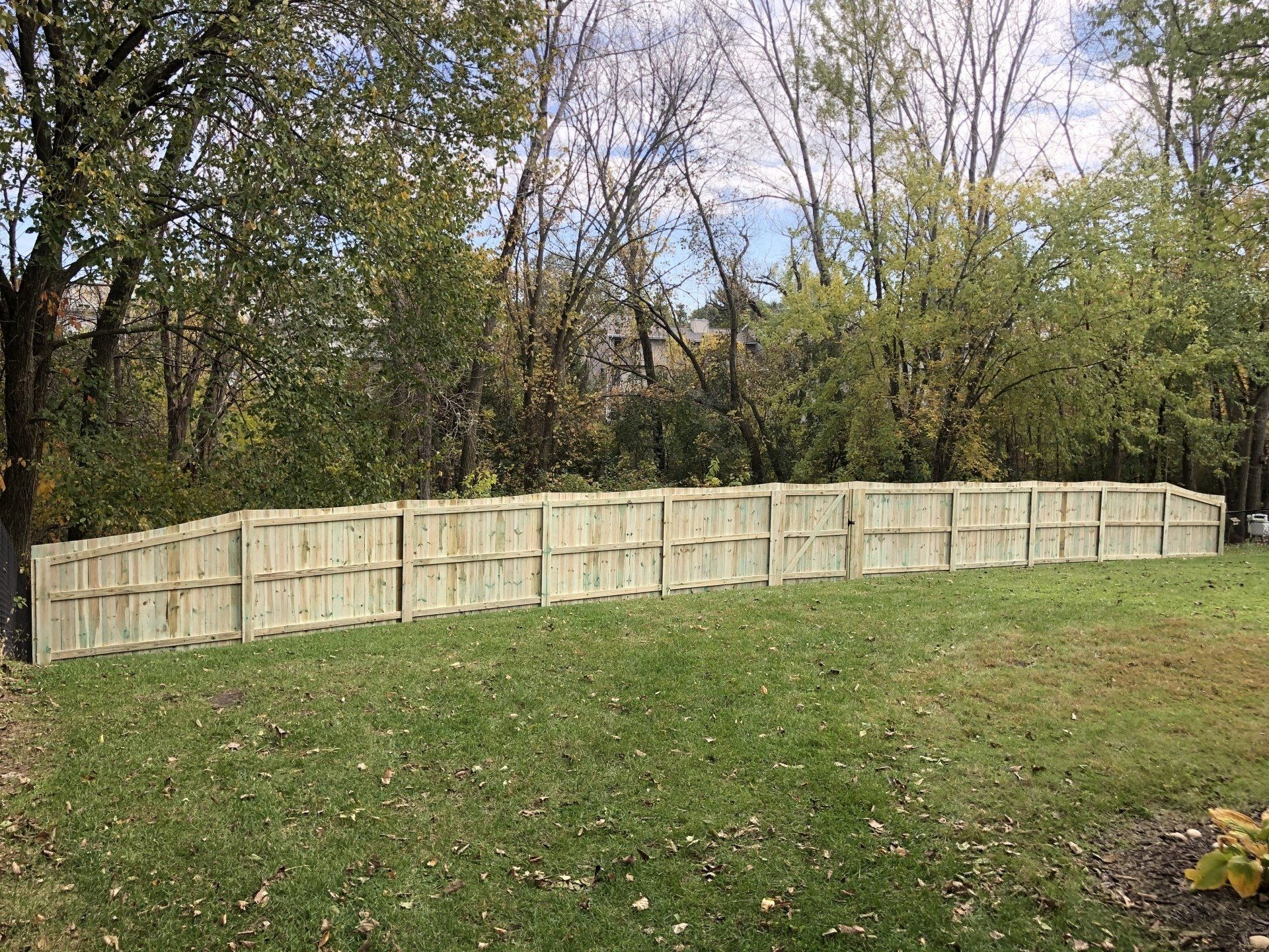 A wooden fence is sitting in the middle of a lush green field.