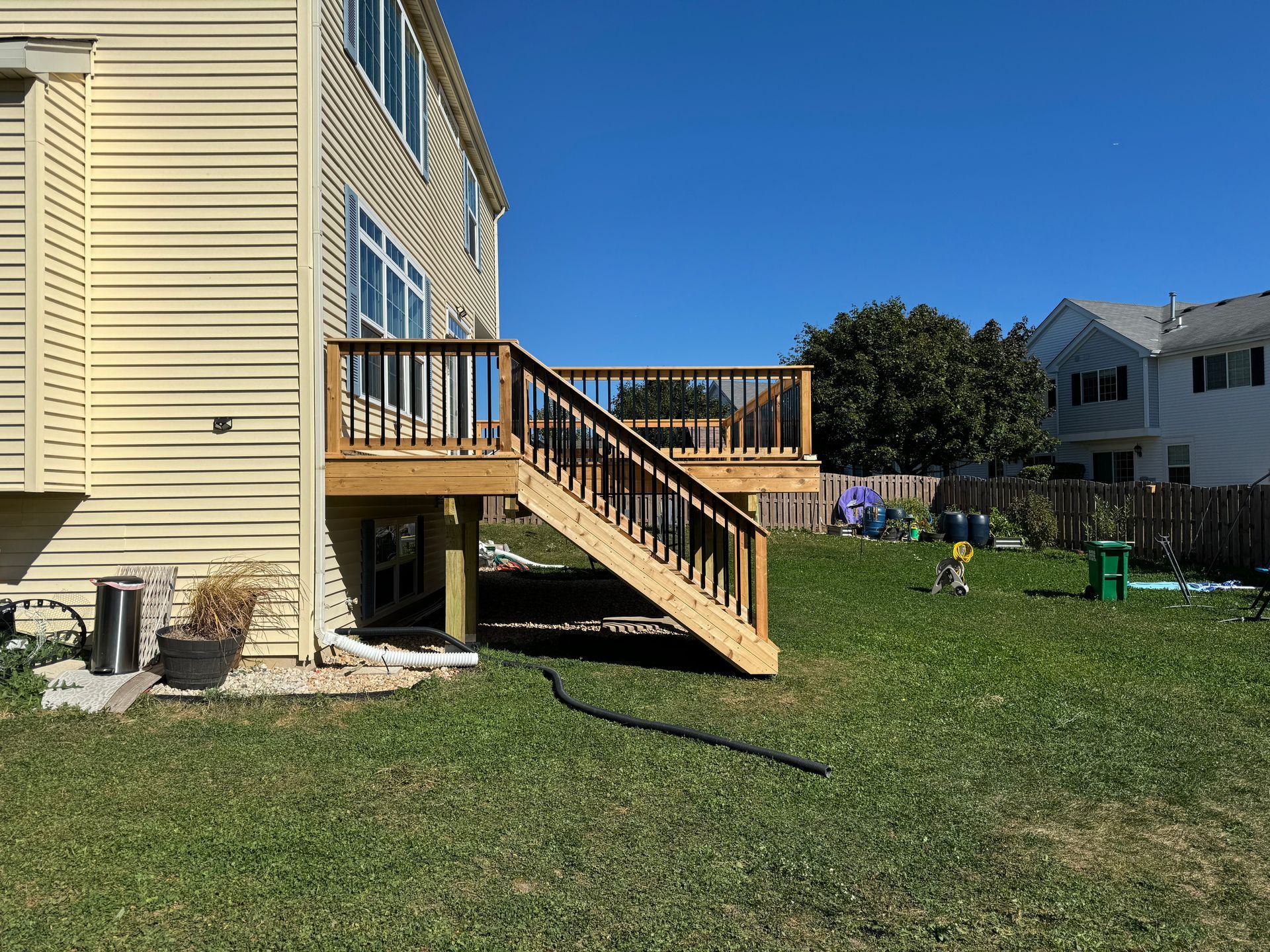A house with a wooden deck and stairs in the backyard.