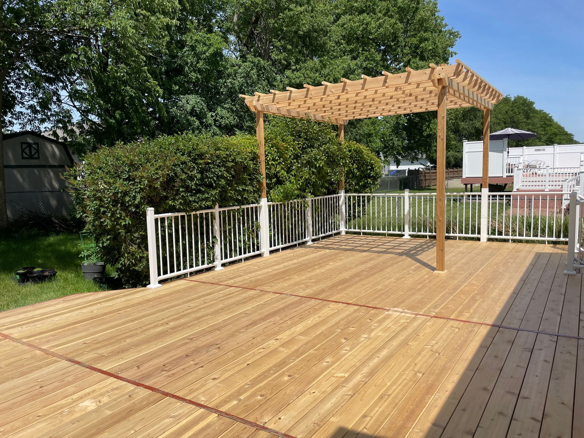 A wooden deck with a pergola on top of it.