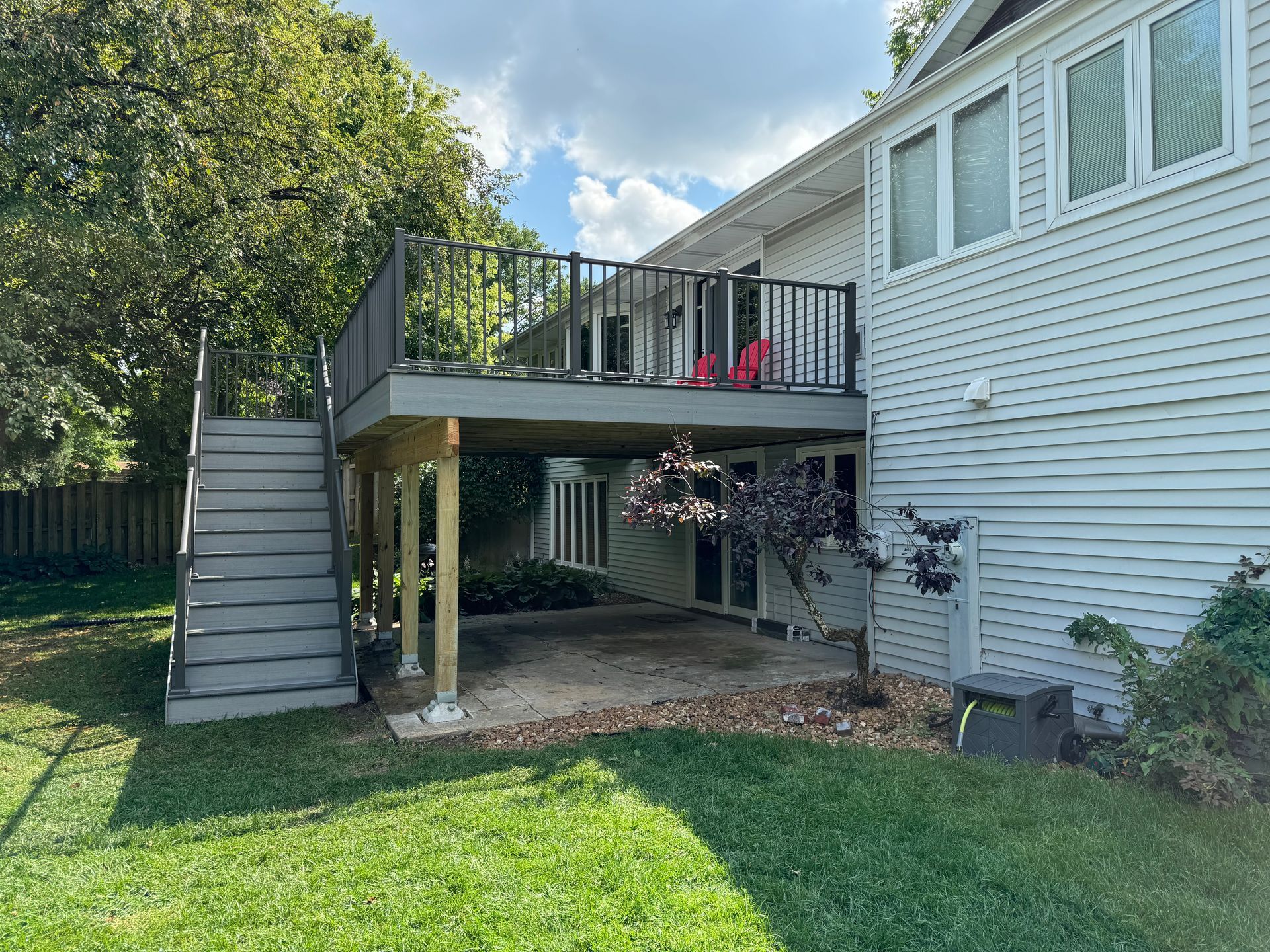 A house with a large deck and stairs in the backyard.
