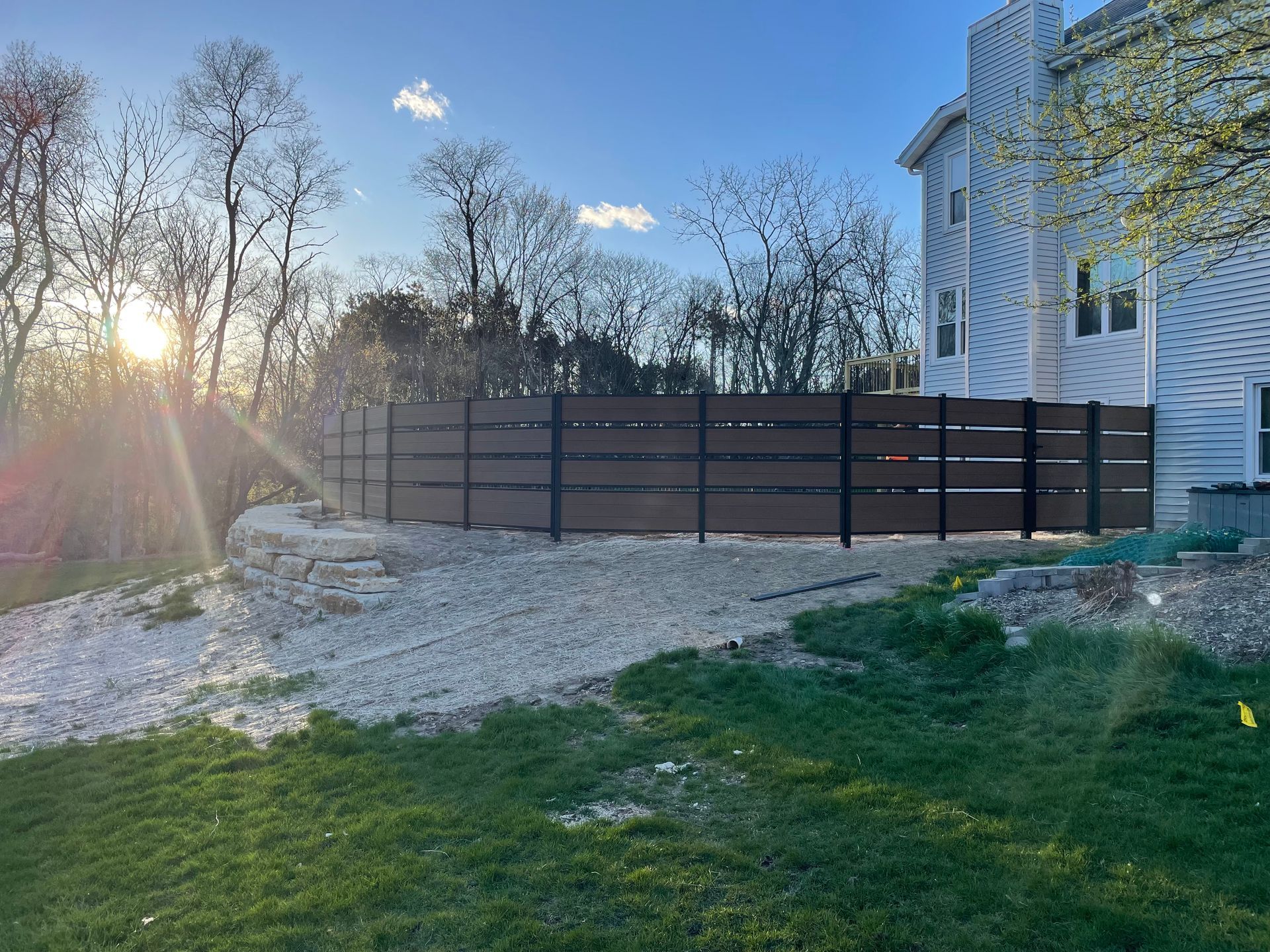 There is a wooden fence in the backyard of a house.