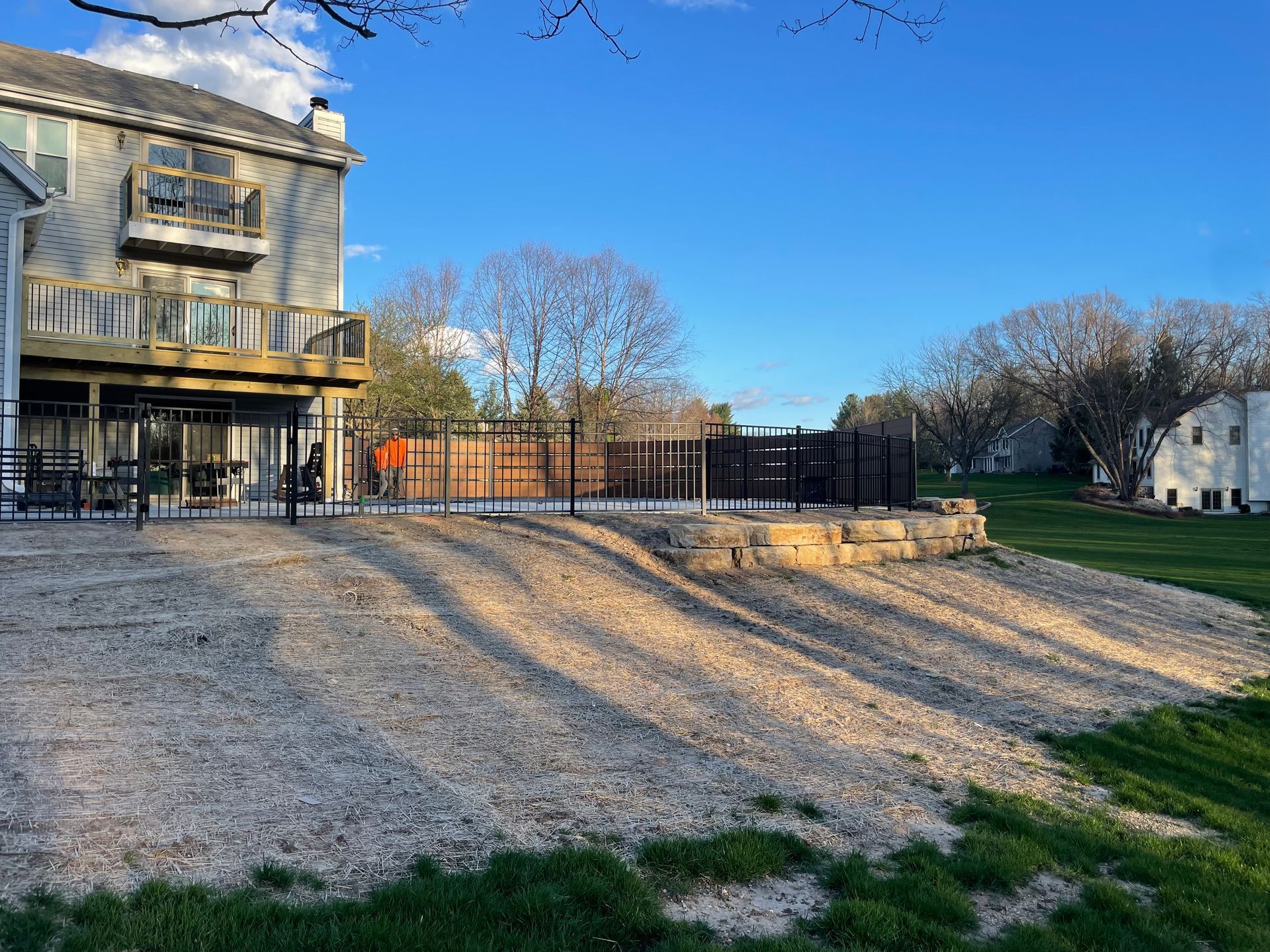 A large house with a deck and a fence in the backyard.