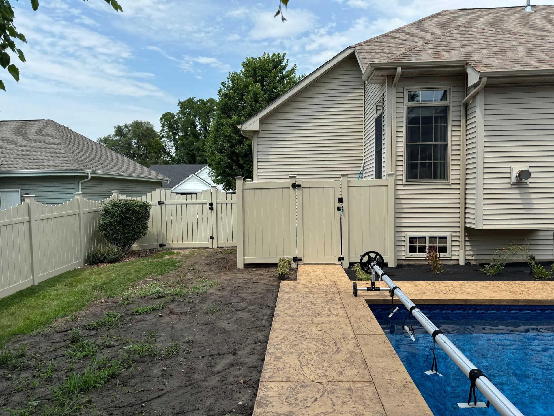There is a swimming pool in the backyard of a house.