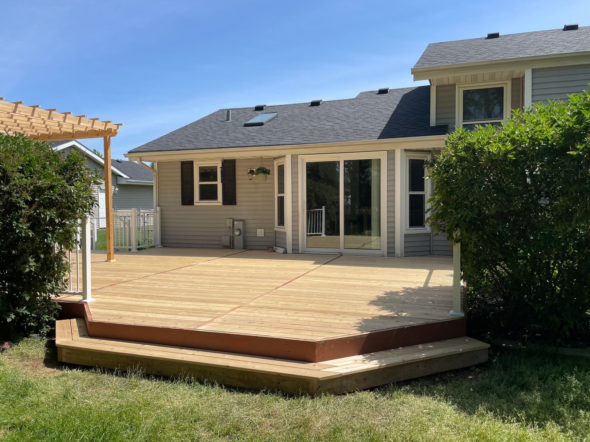 A house with a wooden deck in front of it.