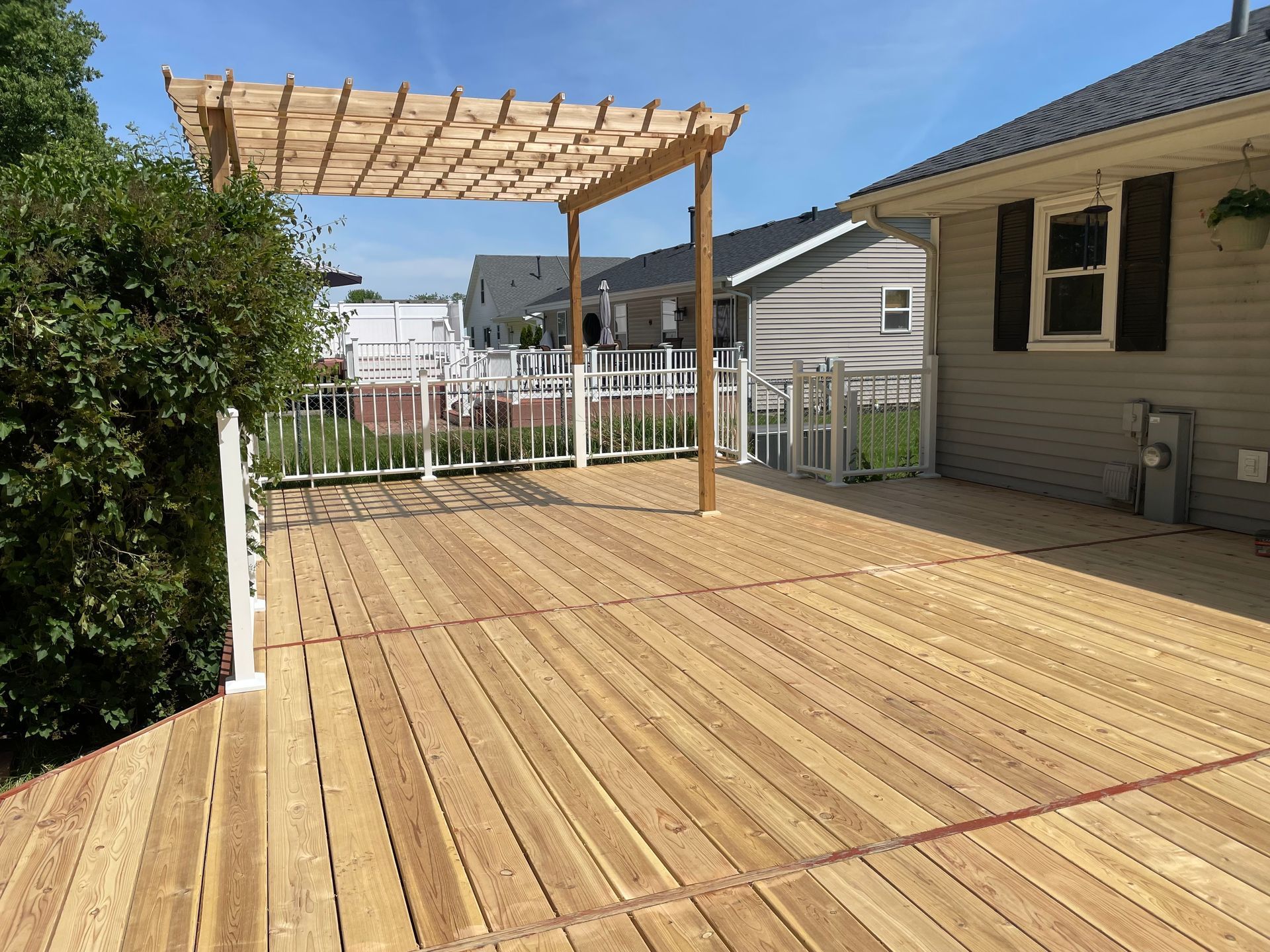 A wooden deck with a pergola on top of it