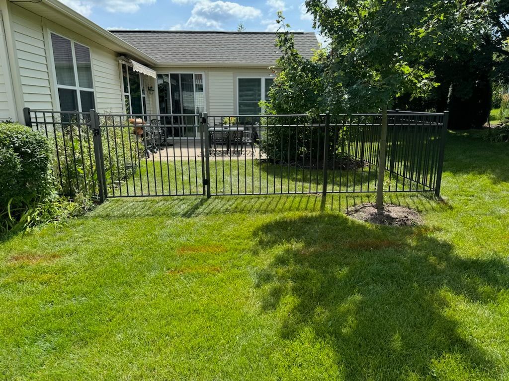 There is a fence in the backyard of a house.