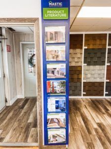 A display of product literature is hanging on a wall in a showroom.