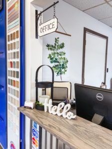 A reception desk with a sign that says office and a sign that says hello.