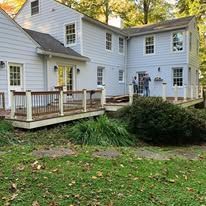 A large white house with a large deck in front of it.