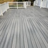 A gray deck with a white railing and a gate.