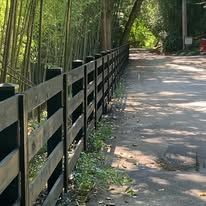 There is a wooden fence along the side of the road.