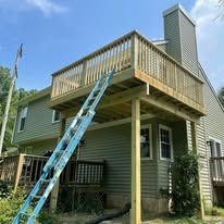 A wooden deck is being built on the side of a house.