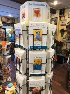 A display of blue mountain arts greeting cards in a store