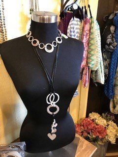 A black mannequin is wearing a necklace with a heart pendant.