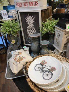 A table topped with plates , vases , candles , and a pineapple.