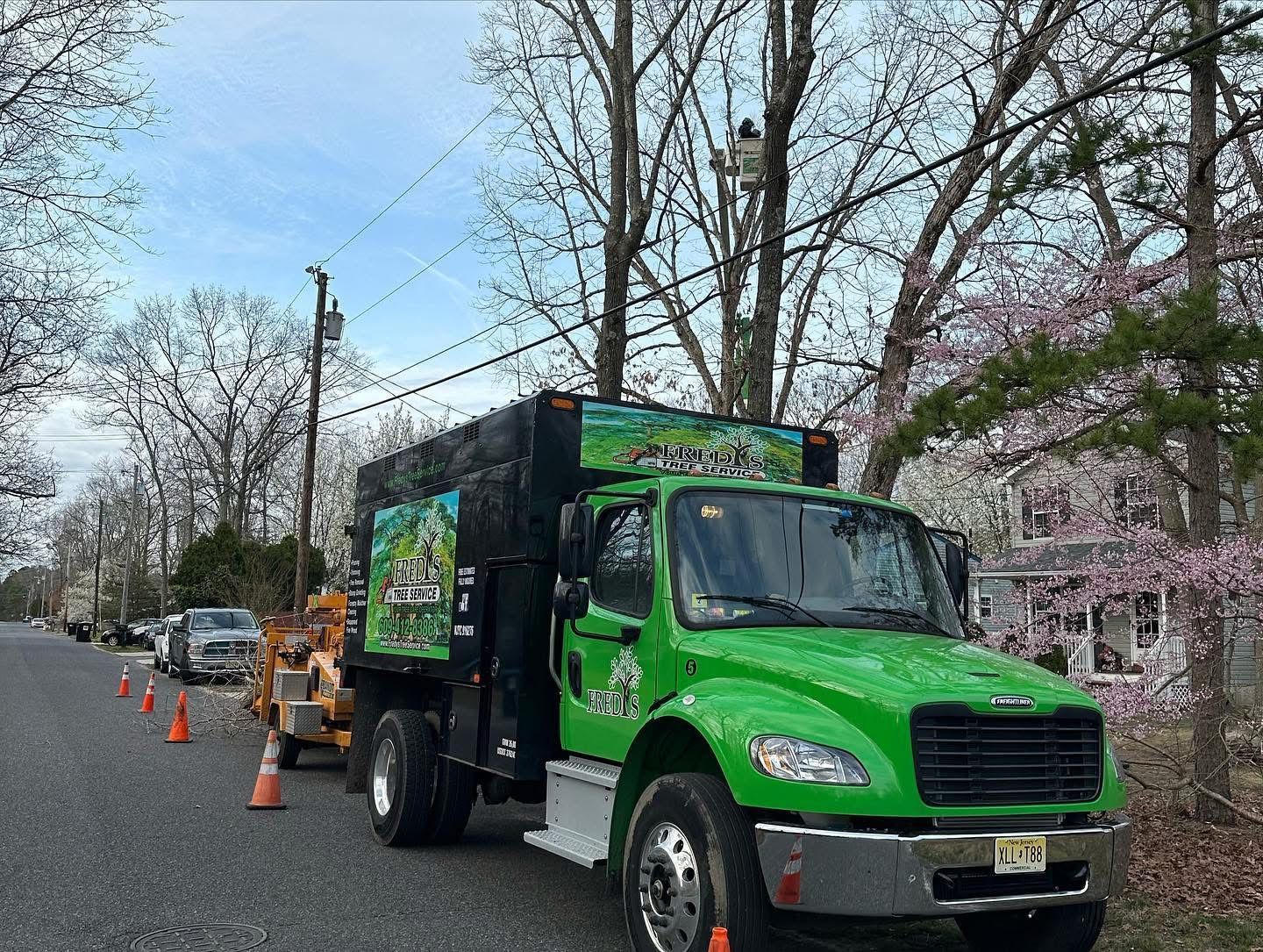 A green truck is parked on the side of the road.