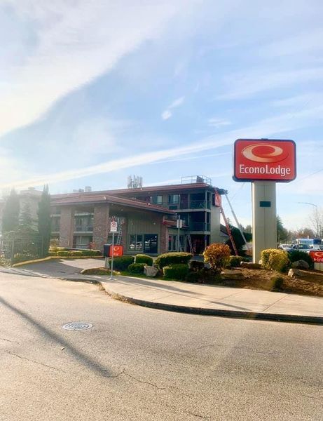 Econo Lodge motel with a red sign, two-story building on a sunny day.