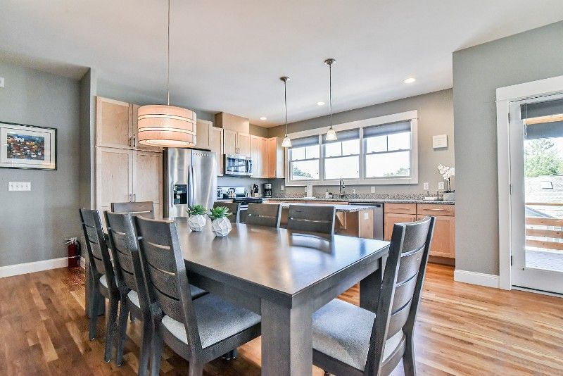 A dining room table and chairs in a kitchen with hardwood floors.