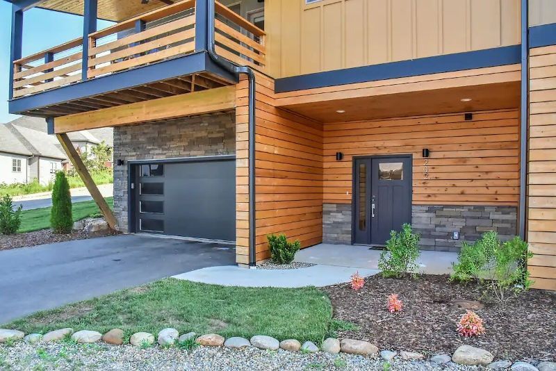 The front of a house with a garage and a balcony.