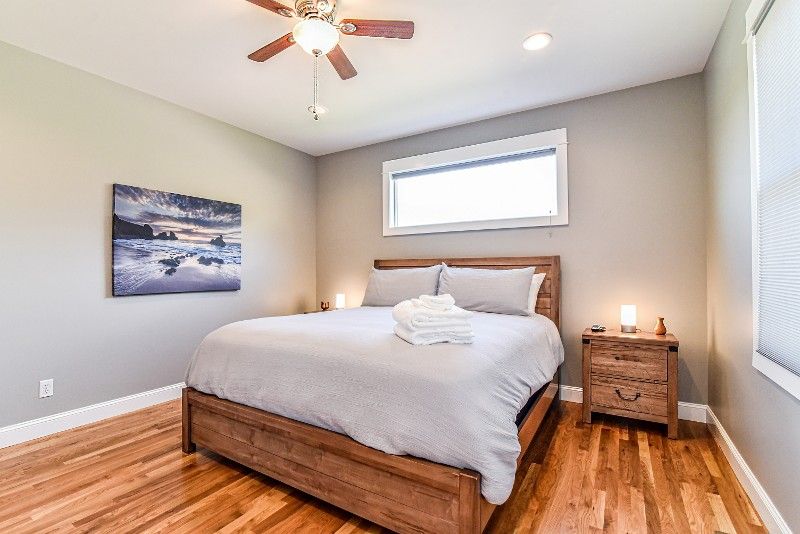 A bedroom with a bed, nightstand, and ceiling fan.