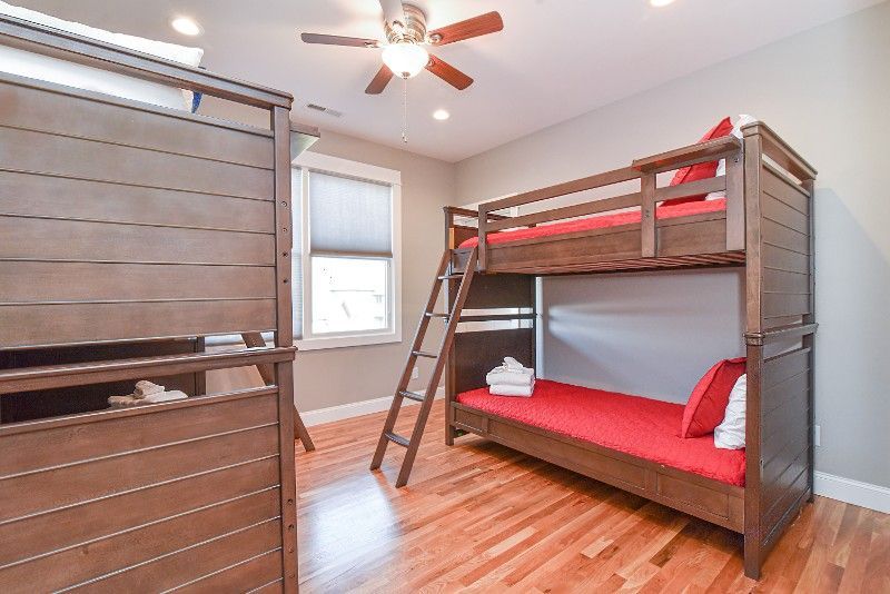 A bedroom with two bunk beds and a ceiling fan.