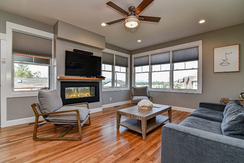 A living room with a couch, chair, coffee table, fireplace, and television.