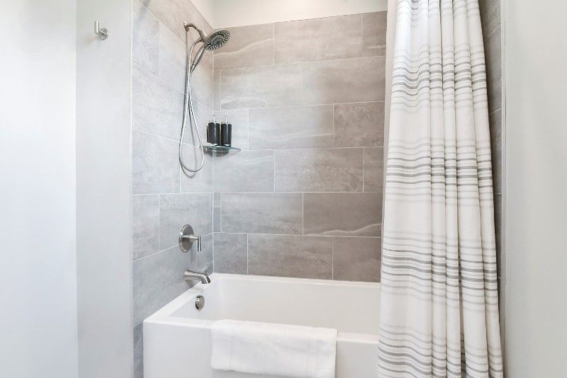 There is a bathtub in the bathroom with a shower curtain.