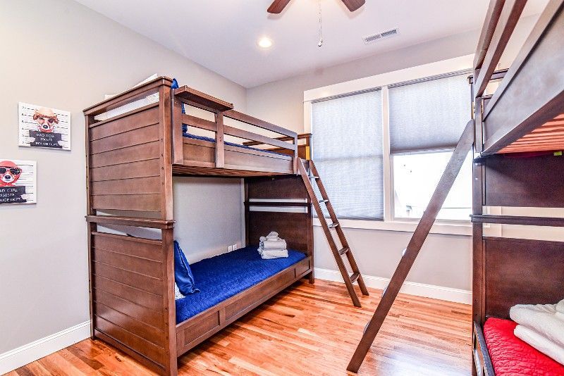 A bedroom with bunk beds and a ceiling fan.