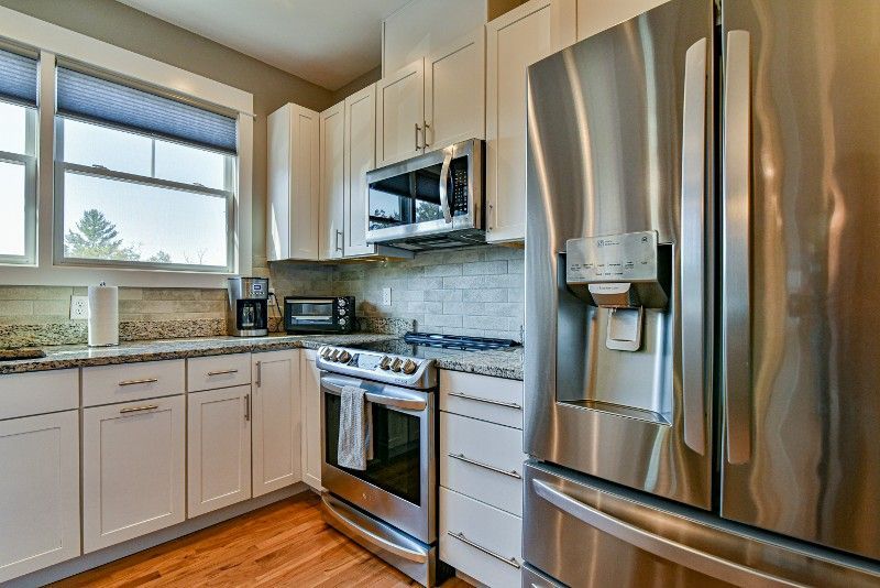 A kitchen with stainless steel appliances and white cabinets.