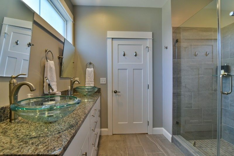 A bathroom with two sinks and a walk in shower.