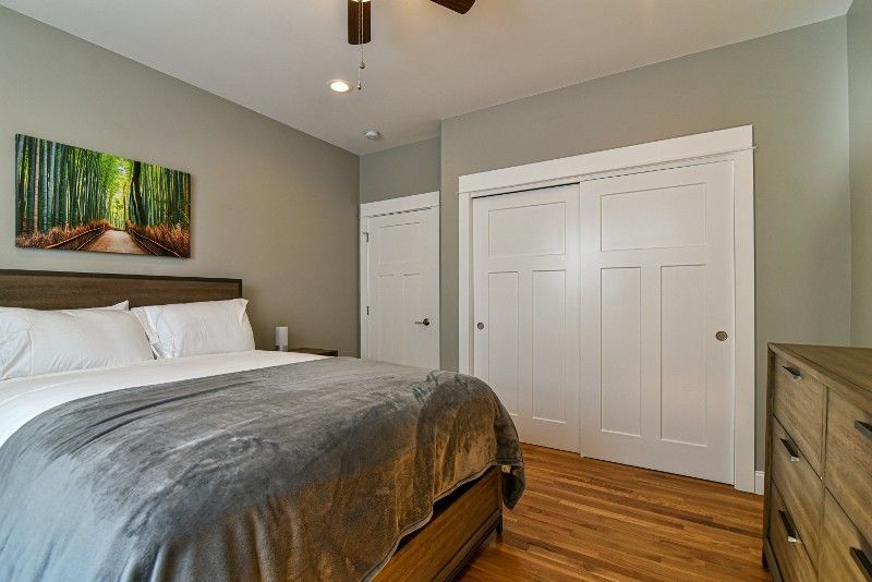 A bedroom with a bed, dresser, and closet.