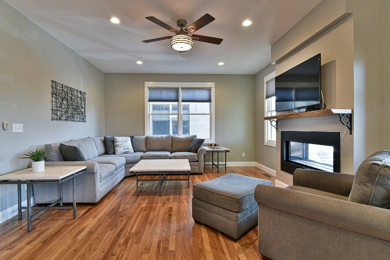 A living room with a large sectional couch and a fireplace.