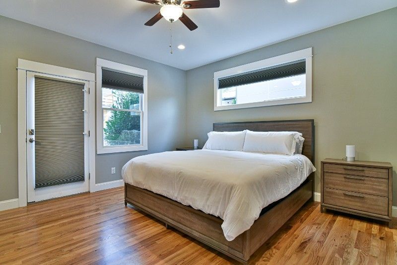 A bedroom with a king size bed and a ceiling fan.