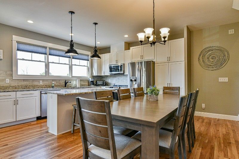 There is a dining table in the middle of the kitchen.
