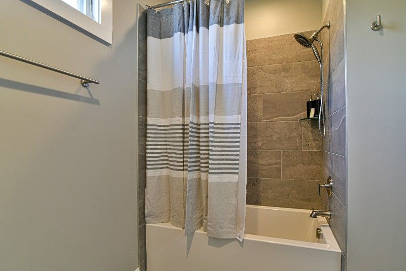 A bathroom with a shower, tub, and shower curtain.