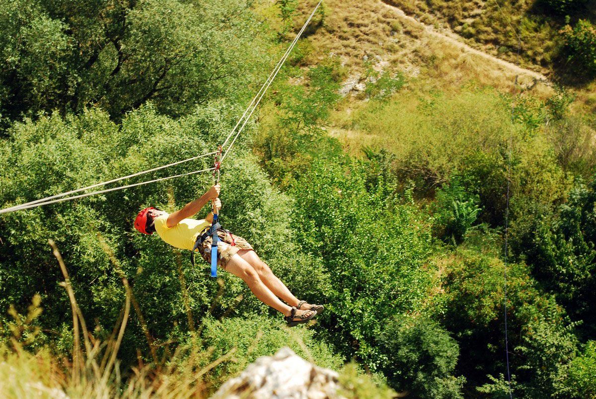 A person is flying through the air on a zip line.