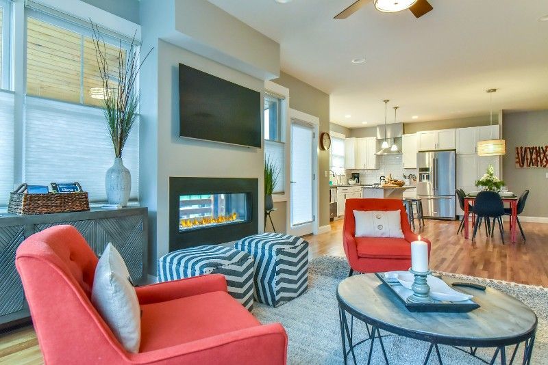 A living room with two red chairs and a fireplace.