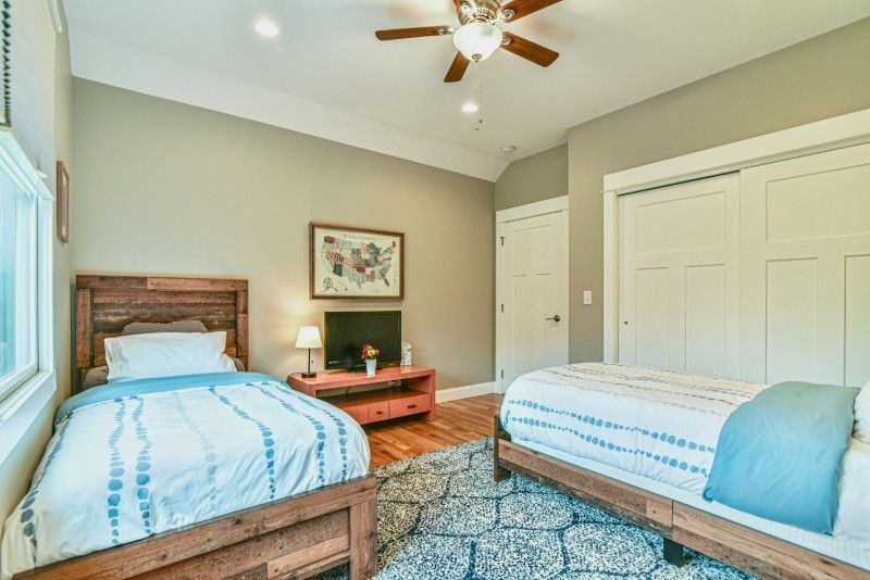 A bedroom with two twin beds and a ceiling fan.